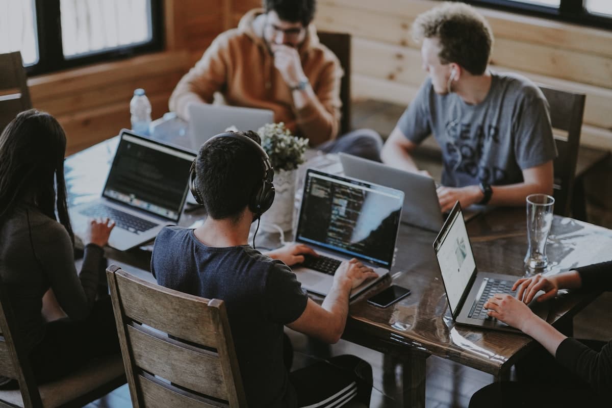 Group of people collaborating around laptop computers in a bright modern office