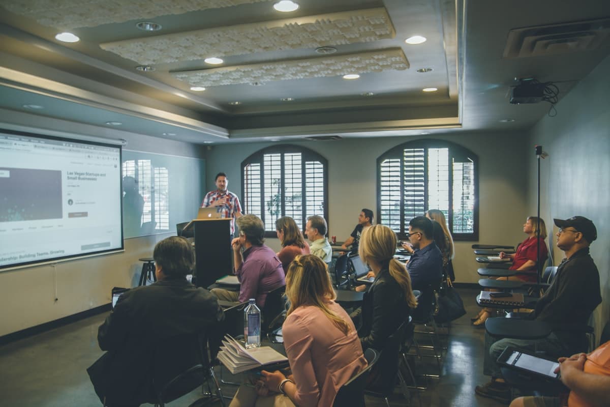 Instructor presenting to a group of people in a bright modern training room