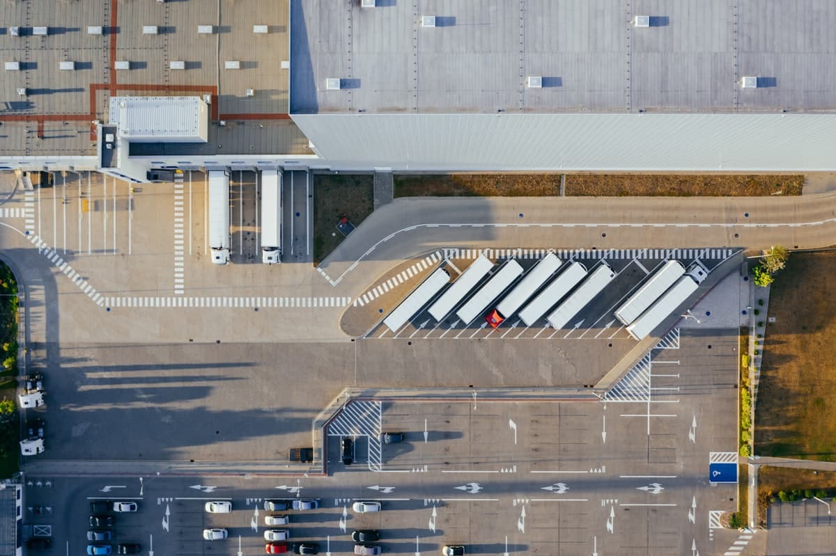 Aerial view of a distribution center with trucks docked at loading bays